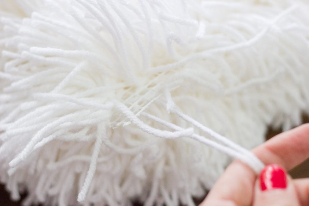 Make a DIY shag pillow using Bucilla RyaTie! It comes with a pom pom making tool which makes latch hook projects easy!